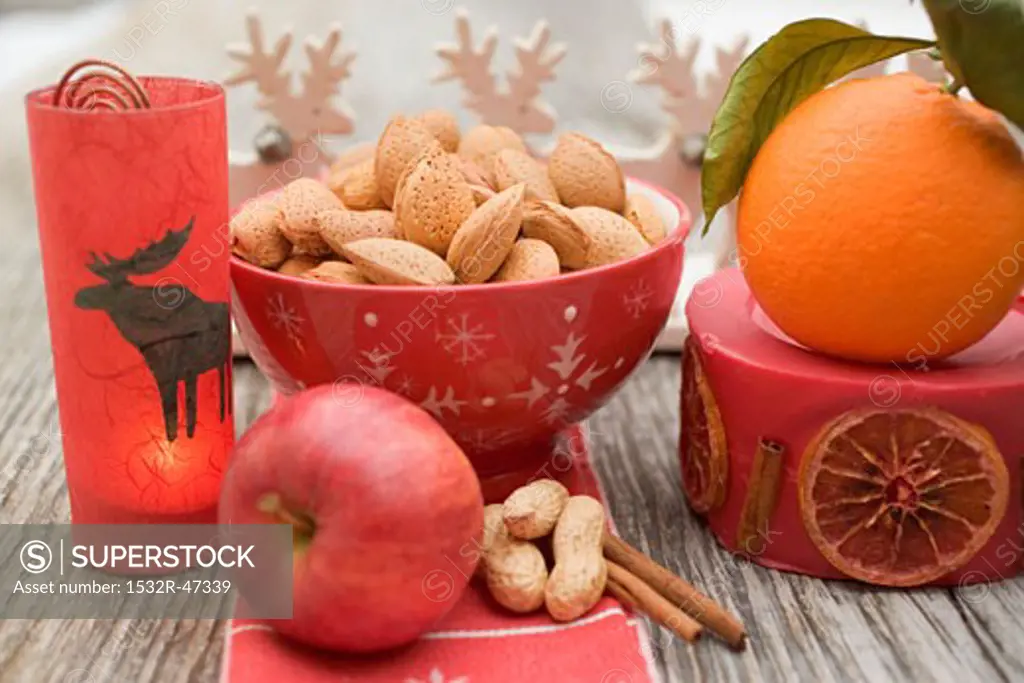 Christmas decoration: nuts, orange, apple, cinnamon, candle