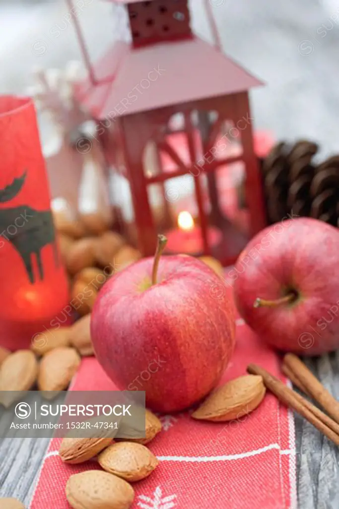 Christmas decoration with apples, nuts, cinnamon & lantern