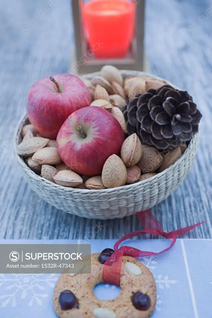 Christmas decoration with apples, nuts, candle & gingerbread