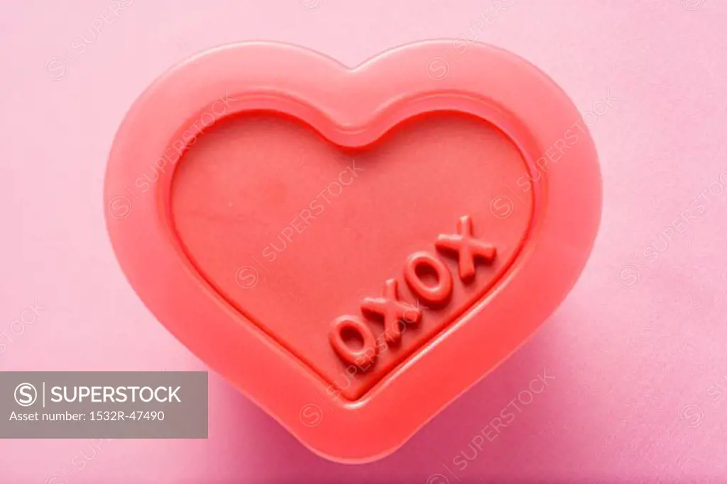 Heart-shaped plastic mould with the words XOXO (Valentine's day)