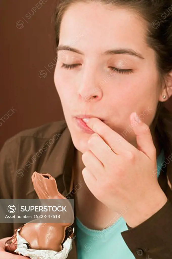 Woman holding chocolate Easter Bunny with a bite taken