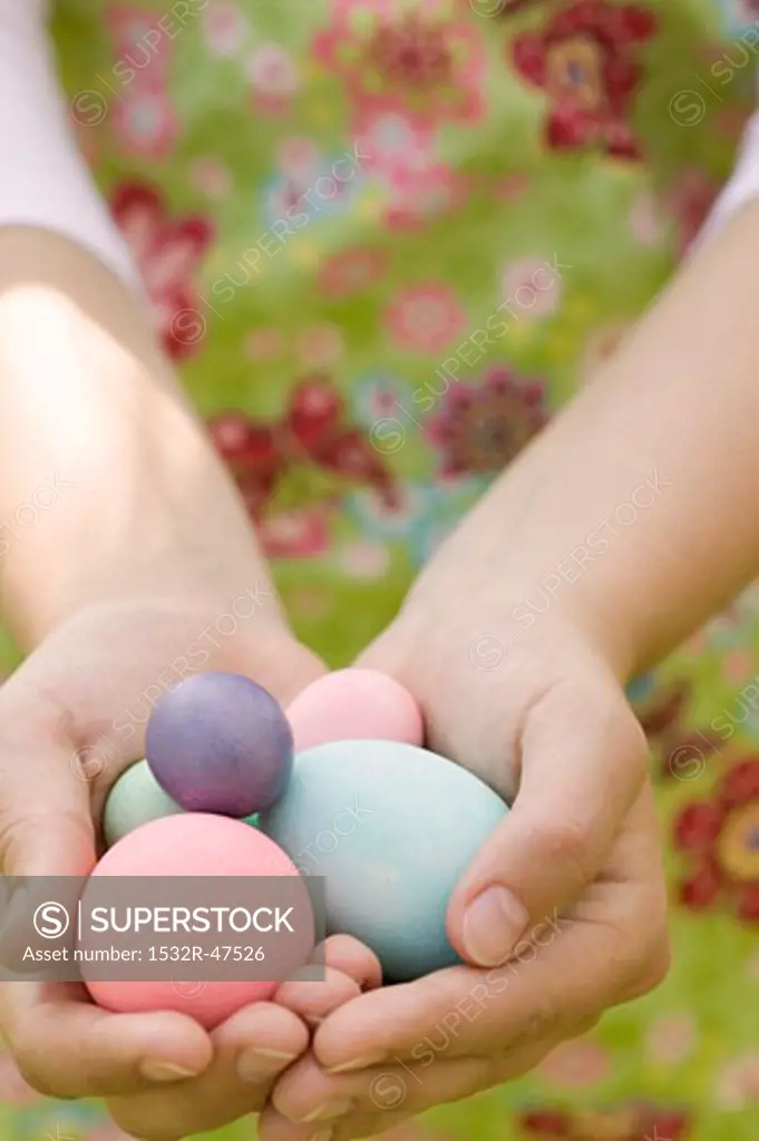 Hands holding coloured eggs