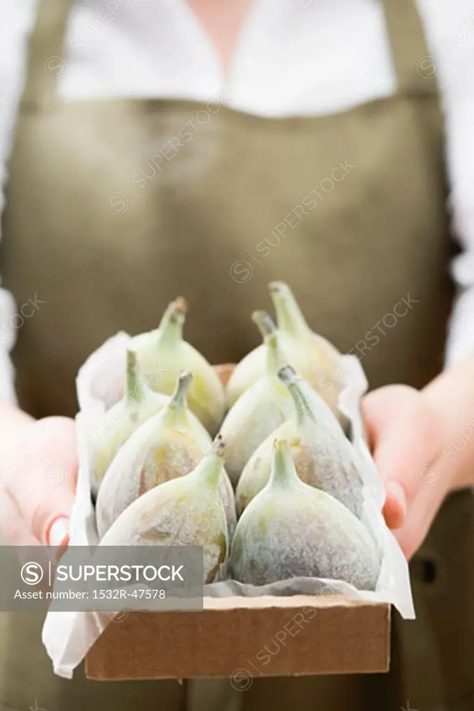 Woman holding box of fresh figs