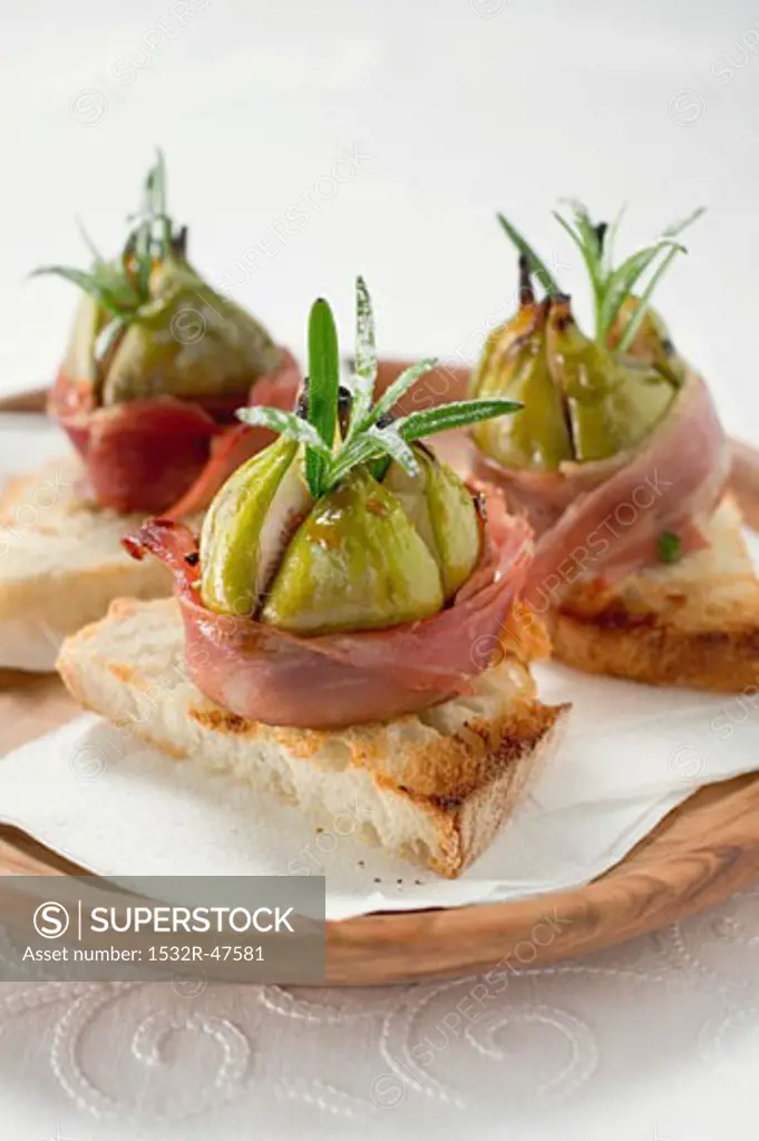 Figs wrapped in raw ham on toast