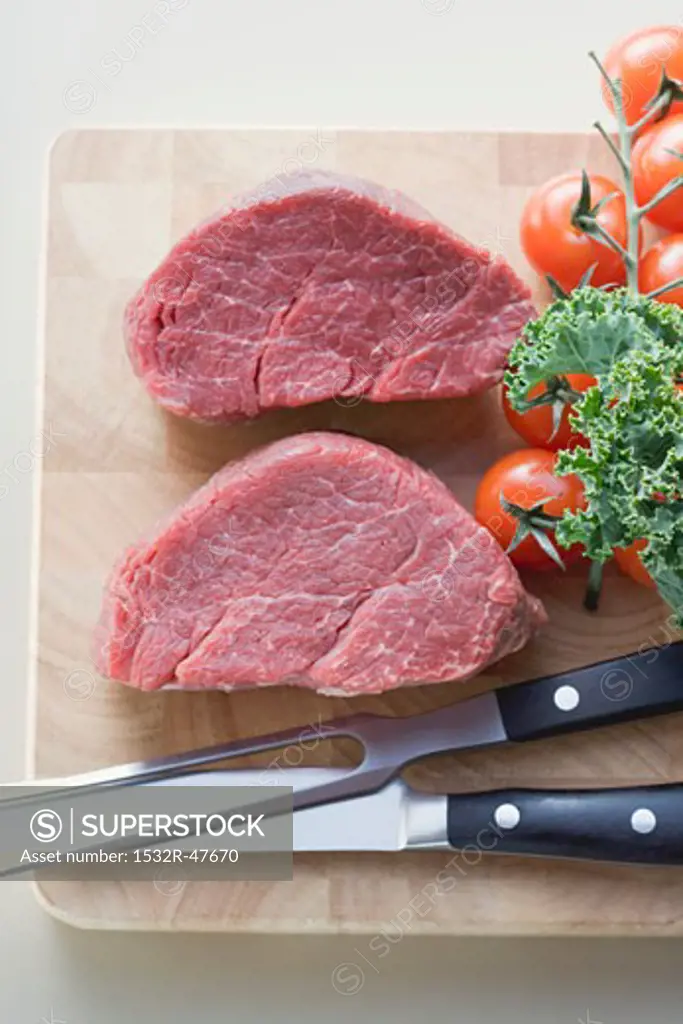 Two pieces of beef fillet on chopping board