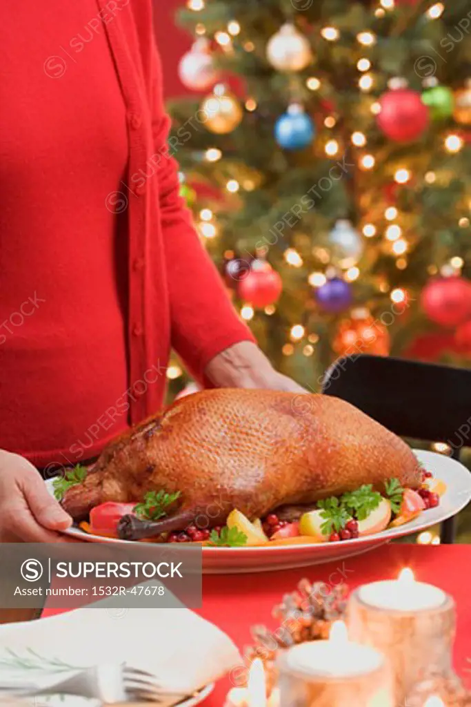 Woman serving roast duck (Christmas)