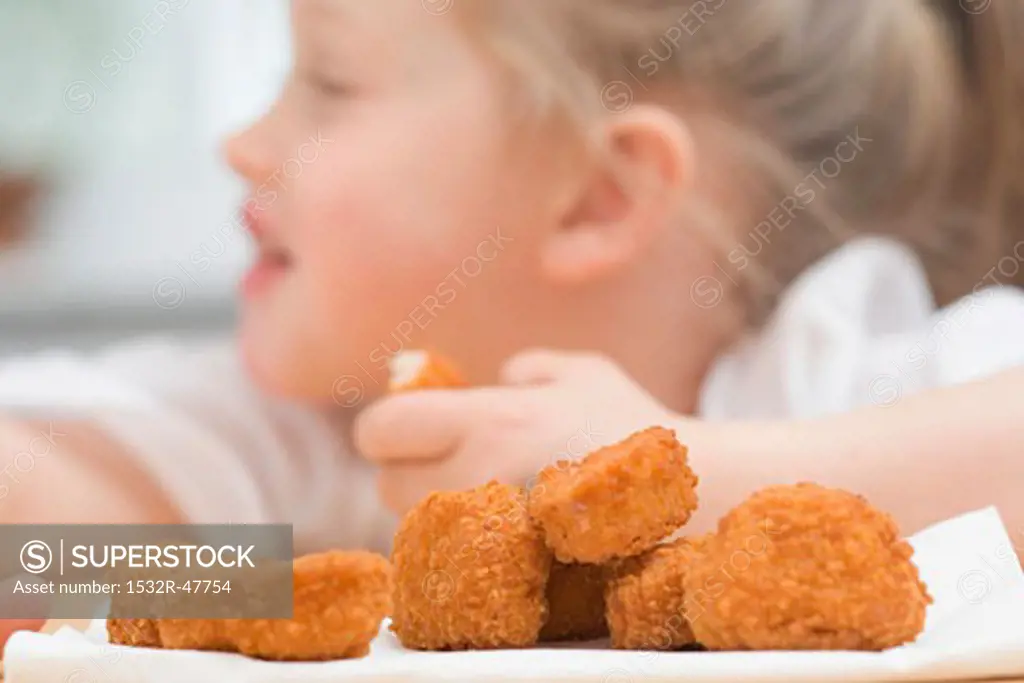 Little girl eating chicken nuggets