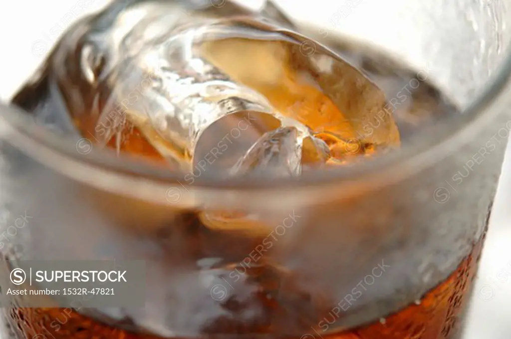Glass of cola with ice cubes (close-up)
