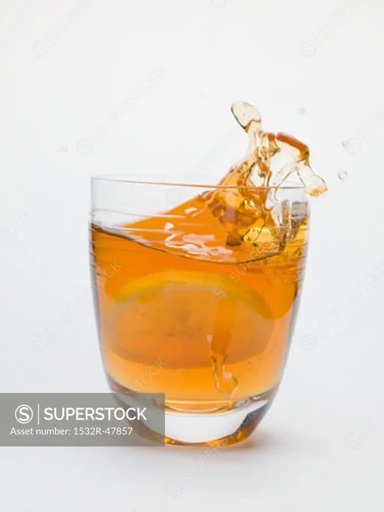Iced tea splashing out of a glass