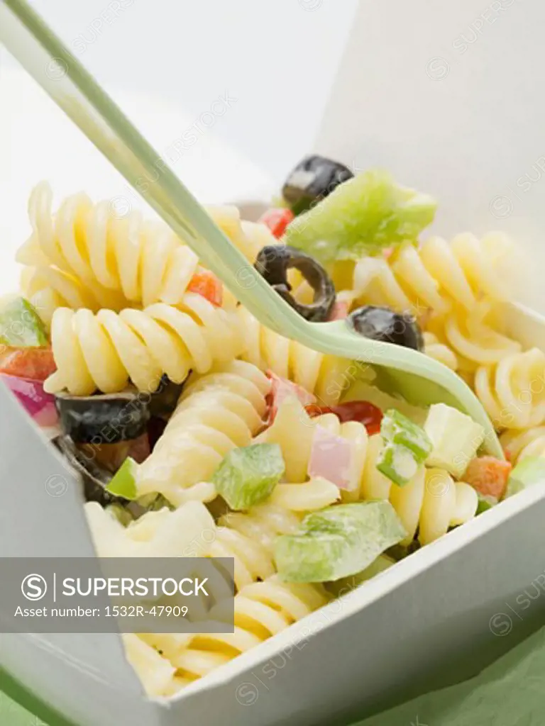 Fusilli with vegetables in take-away container (close-up)