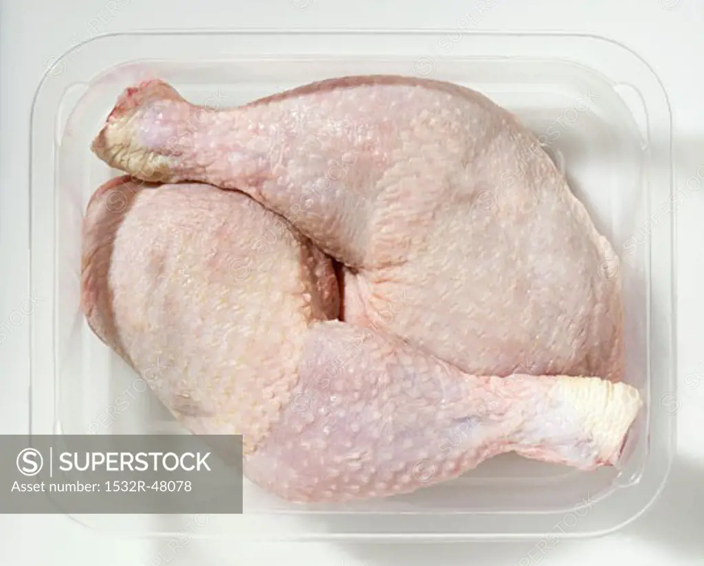 Two chicken legs in plastic container