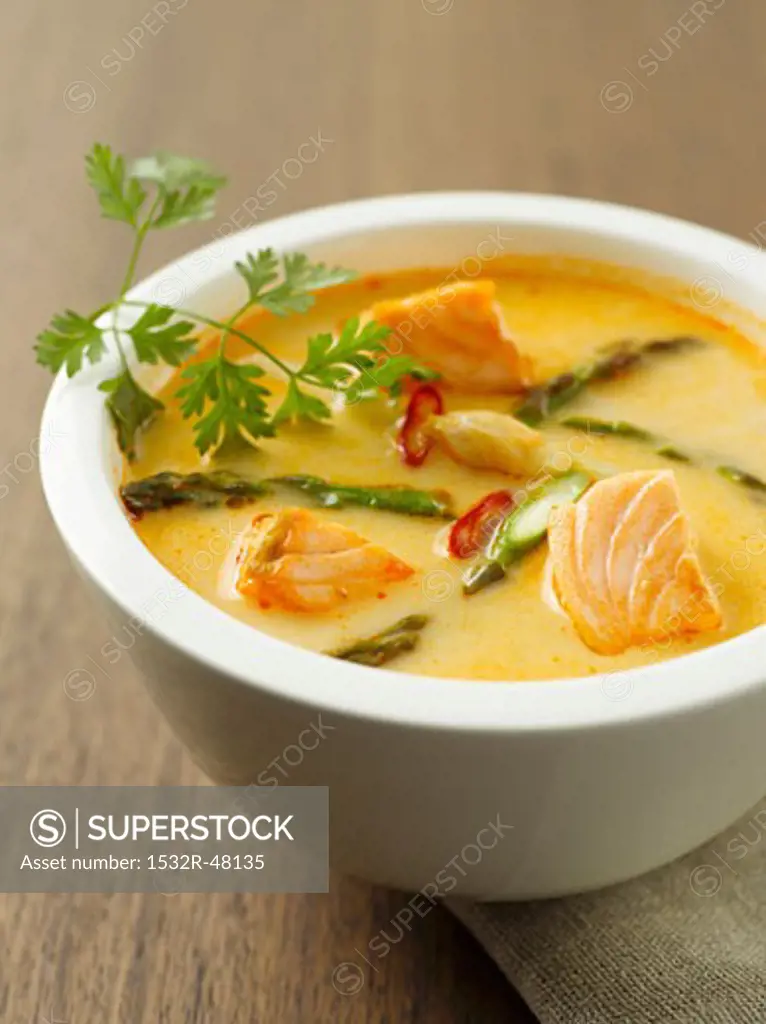 Salmon soup with asparagus and chilli rings