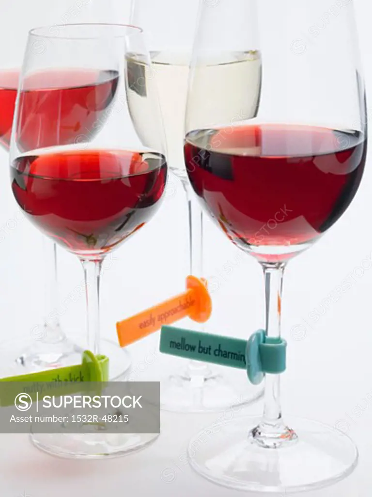 Glasses of wine with plastic labels describing the wine