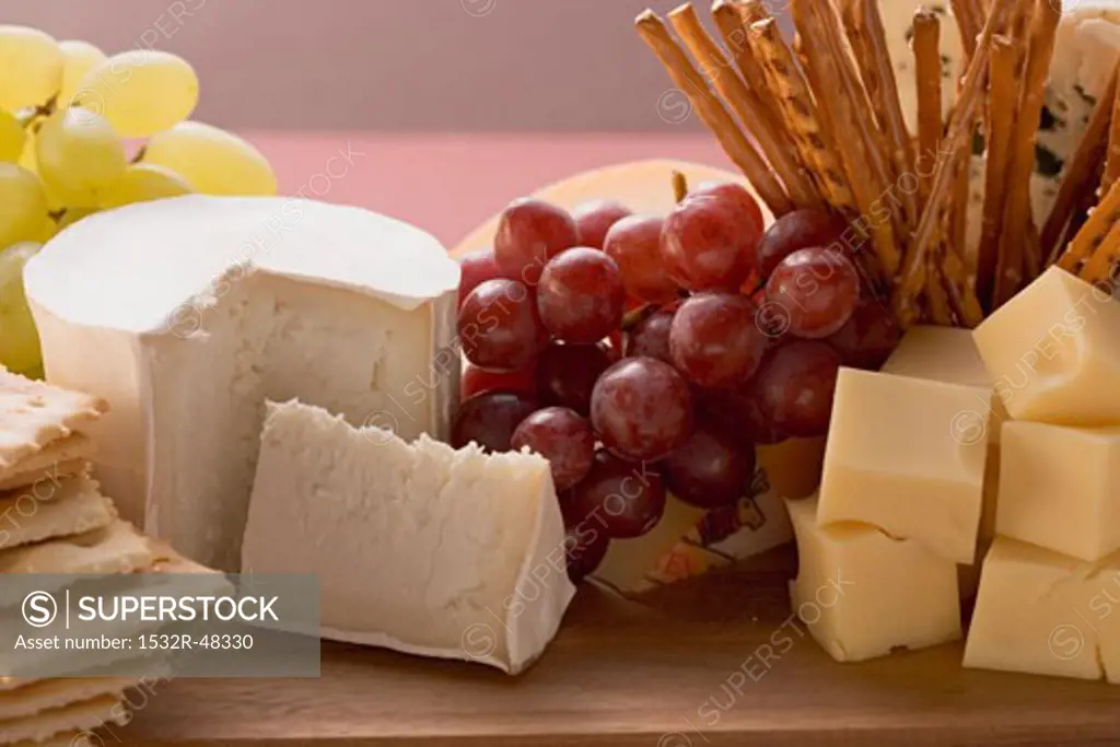 Cheese board with grapes and salted sticks