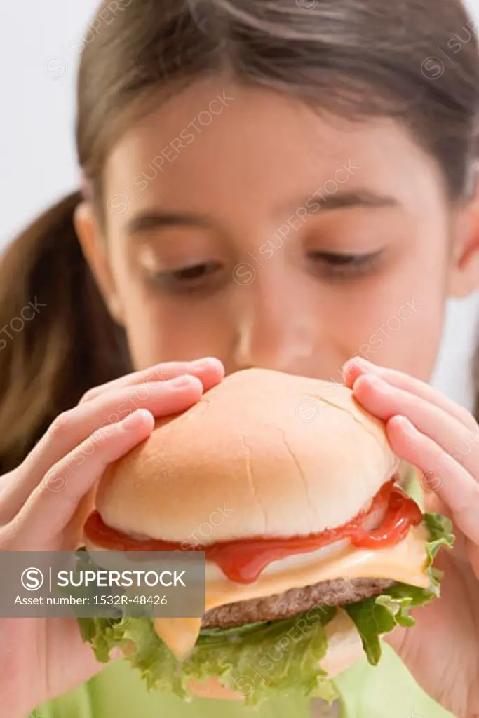 Little girl eating cheeseburger