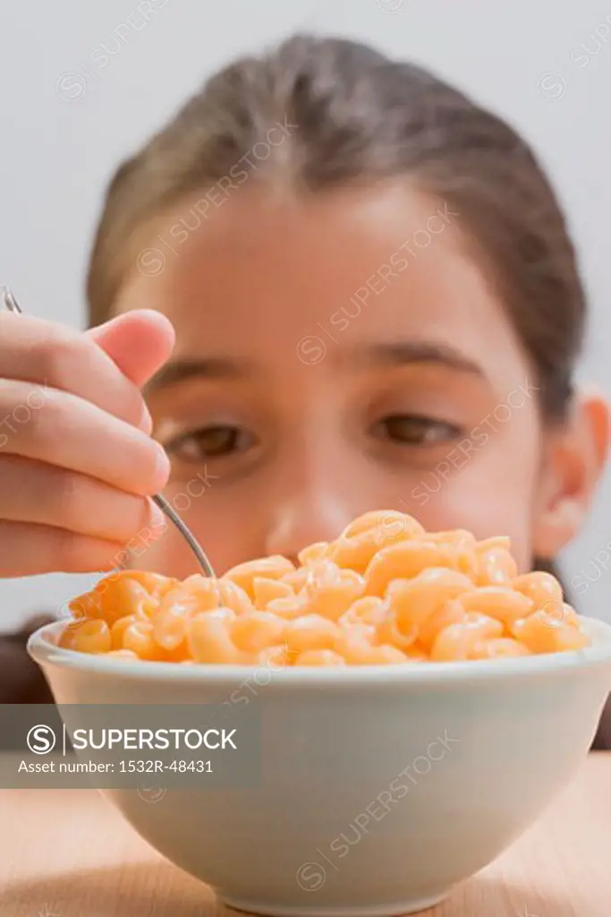 Little girl eating macaroni cheese