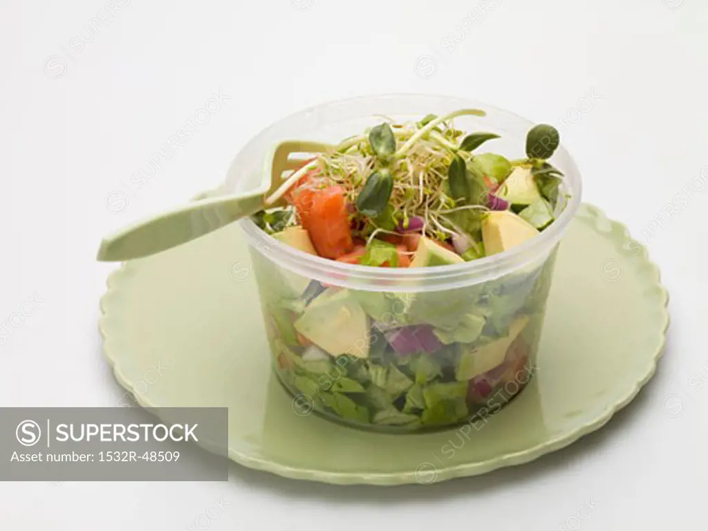 Avocado salad with sprouts in plastic container