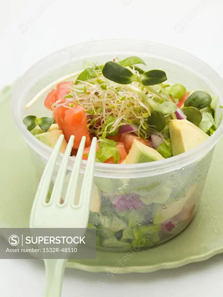 Avocado salad with sprouts in plastic container with fork