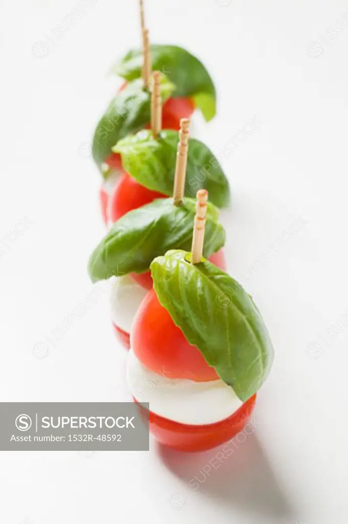 Tomatoes, mozzarella and basil on cocktail sticks