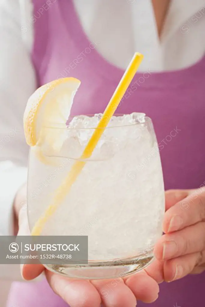 Woman holding glass of lemonade with straw