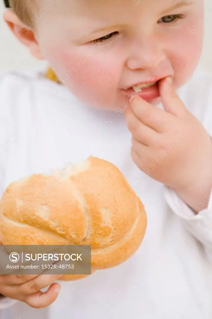 Baby eating a bread roll