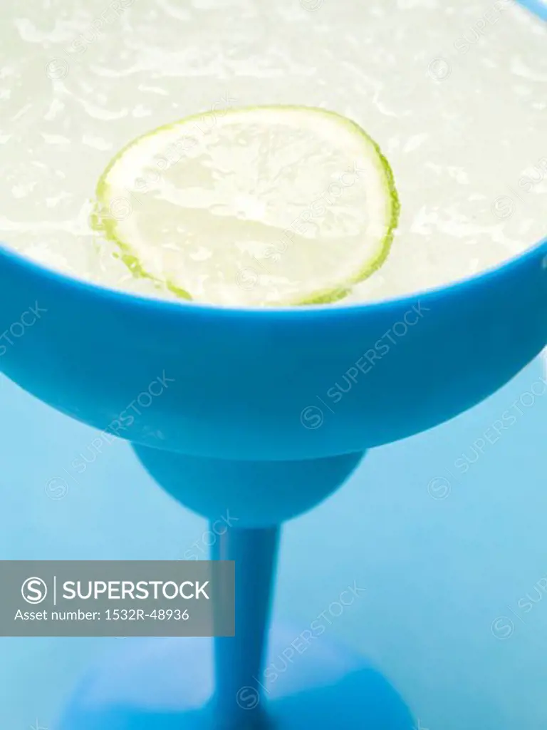 Frozen Margarita with slice of lime in blue glass