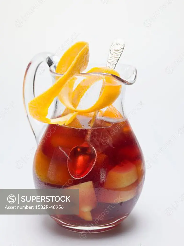 Sangria in a glass jug with orange peel