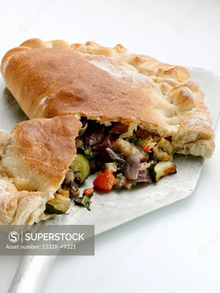 Calzone with vegetable filling on pizza peel