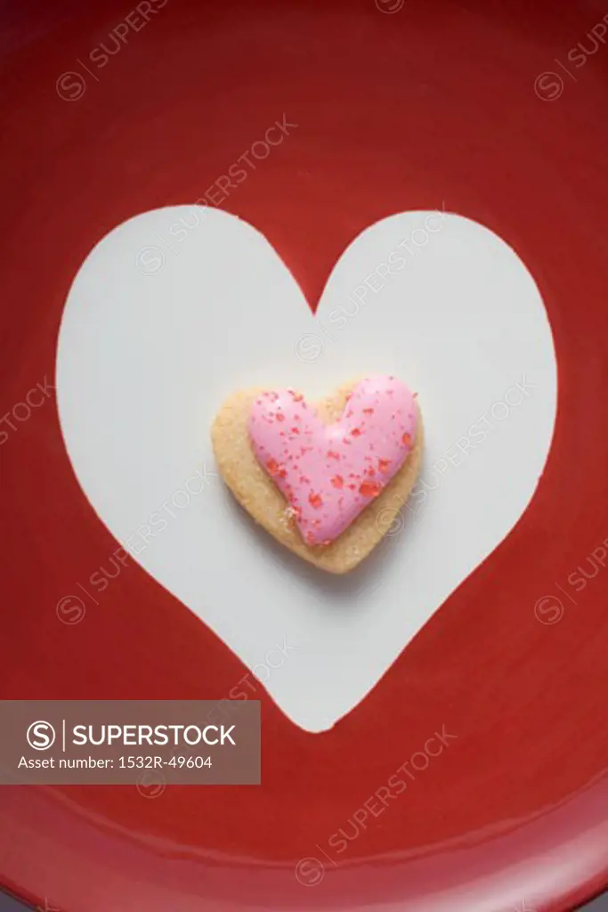 An iced, heart-shaped biscuit in a white heart