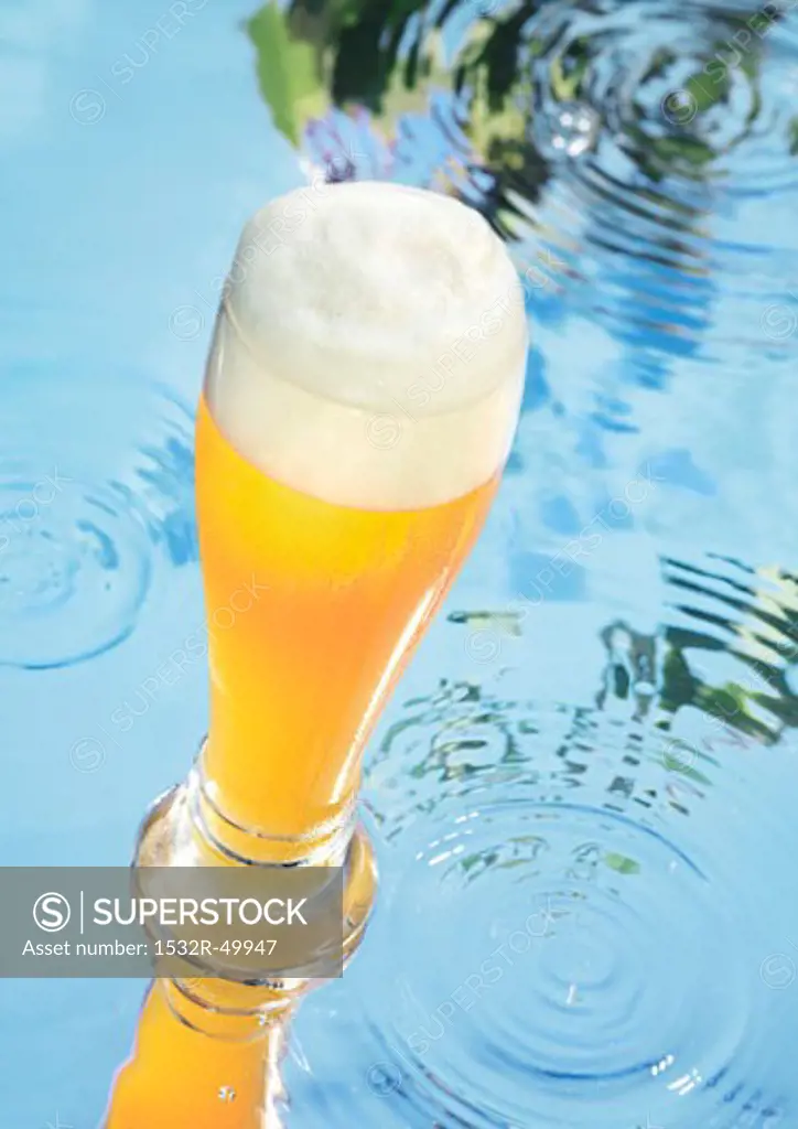 Glass of wheat beer on water