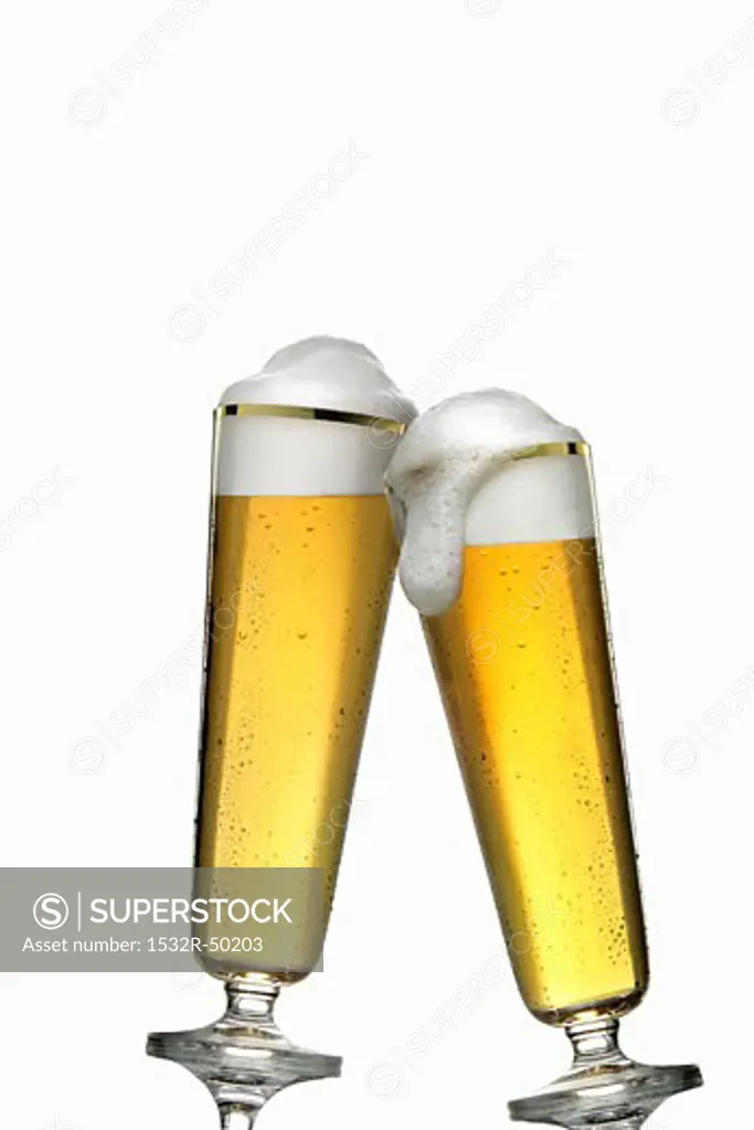Two glasses of pils clinking together