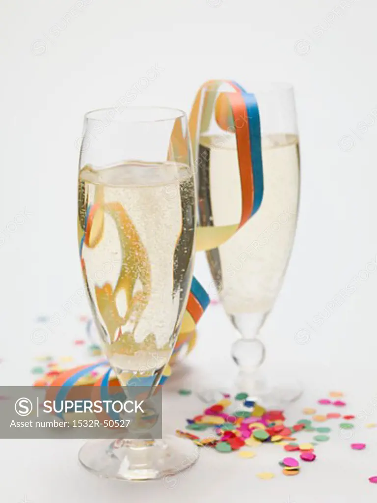 Two glasses of sparkling wine, paper streamer and confetti
