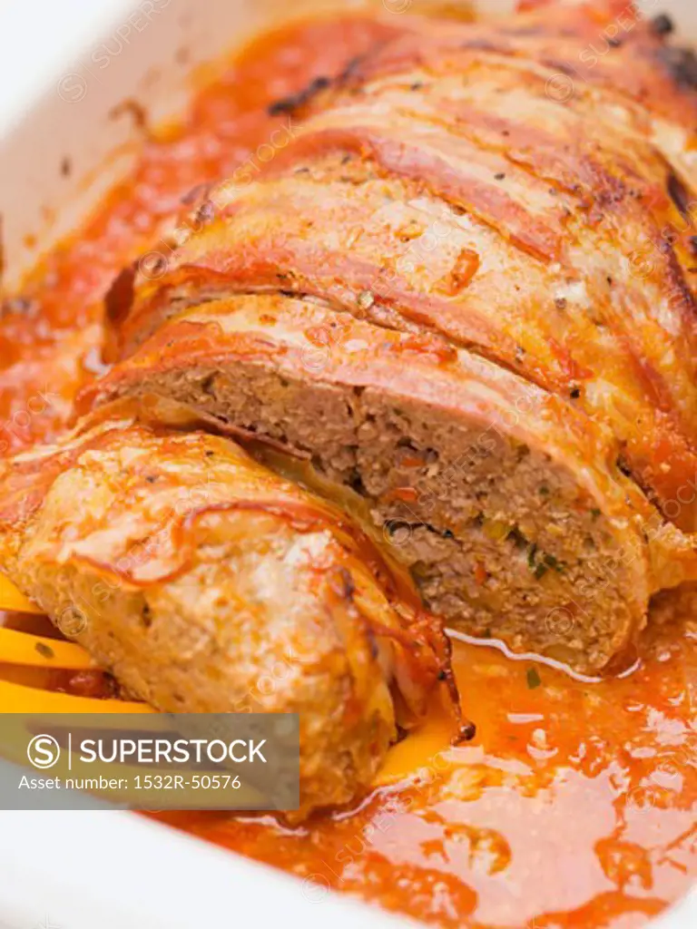Bacon-wrapped meatloaf in tomato sauce