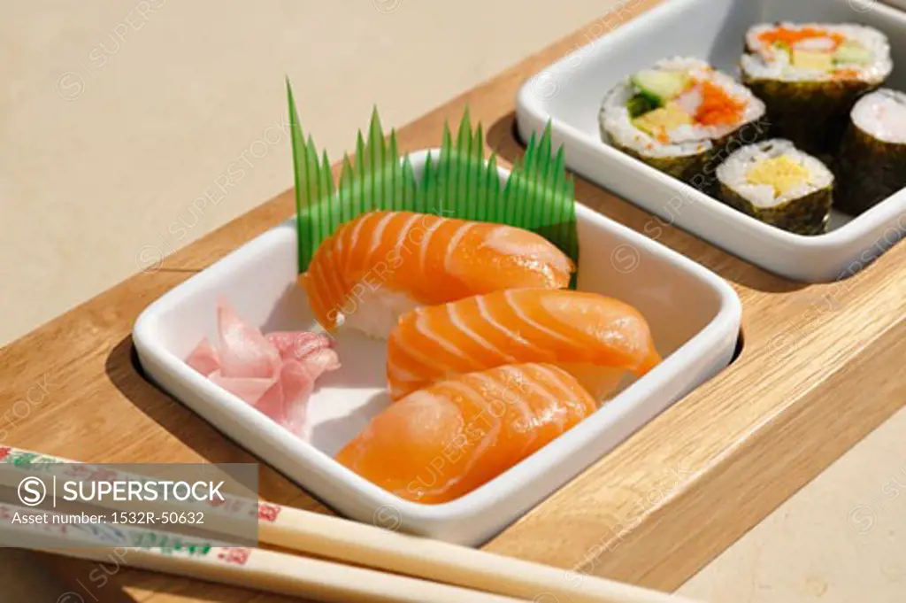 Assorted sushi in dishes with chopsticks