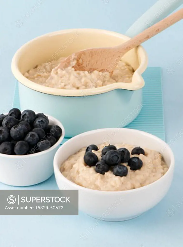 Porridge in a pan and in a bowl with blueberries