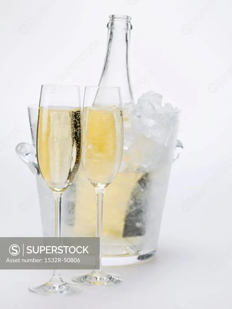 Two glasses of sparkling wine, wine bottle in ice bucket
