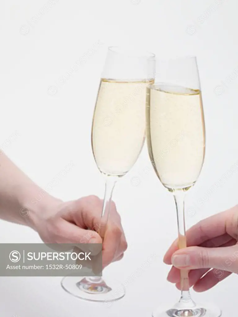 Hands clinking glasses of sparkling wine