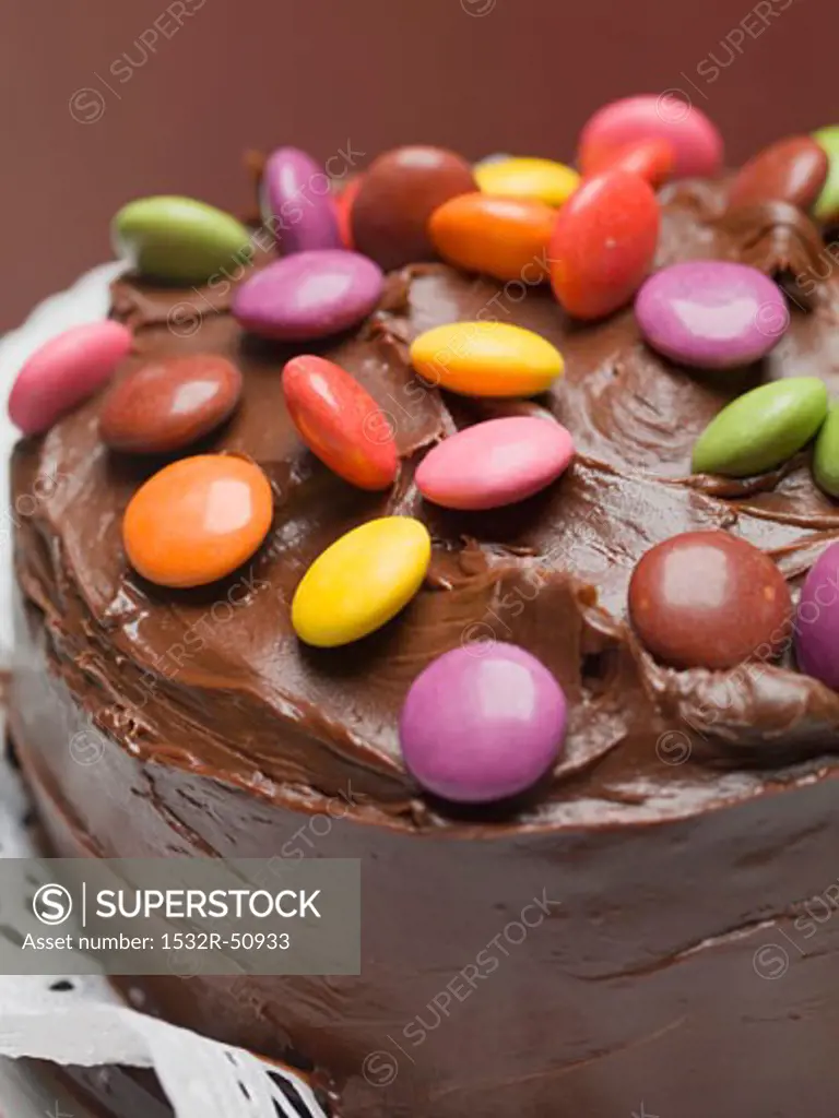 Chocolate cake with coloured chocolate beans (close-up)