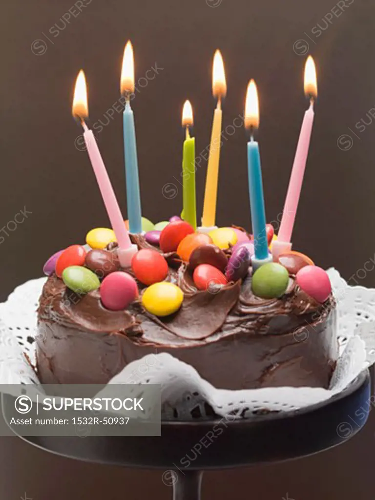 Chocolate cake with coloured chocolate beans and candles