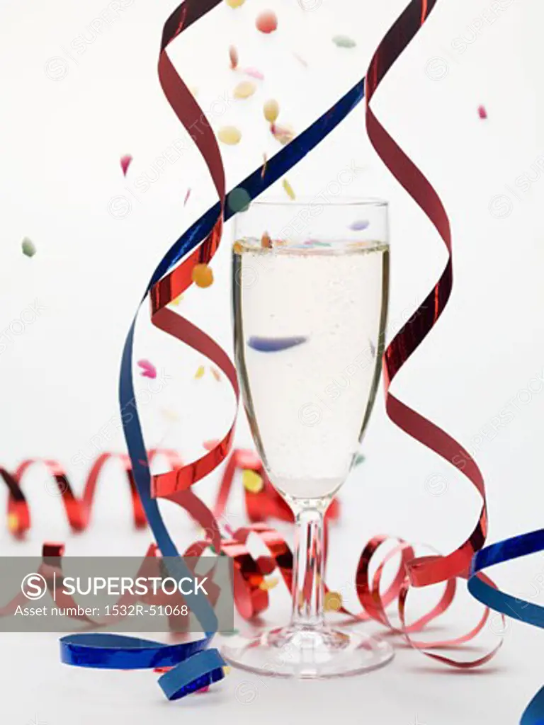 Glass of sparkling wine with party decorations