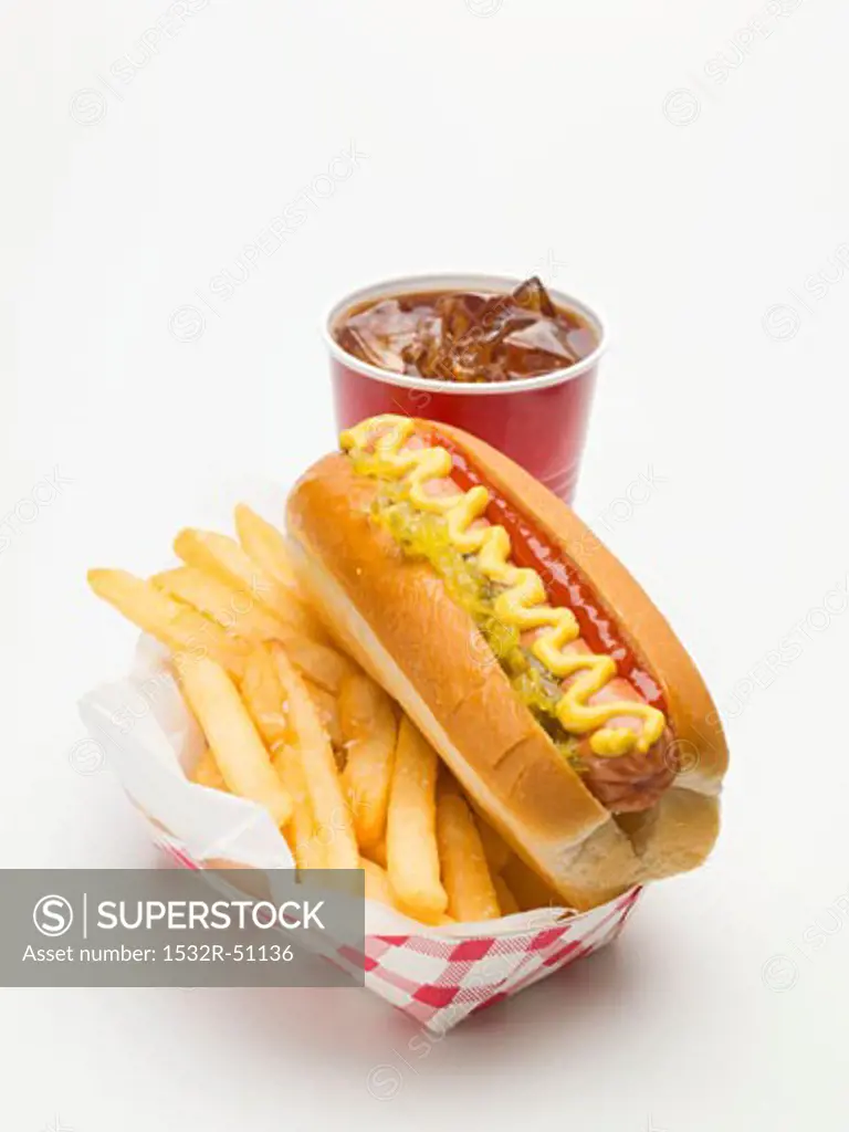 A hot dog with chips and a plastic cup of cola