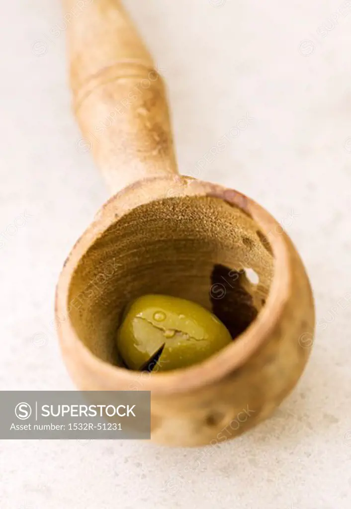 Olive in wooden ladle