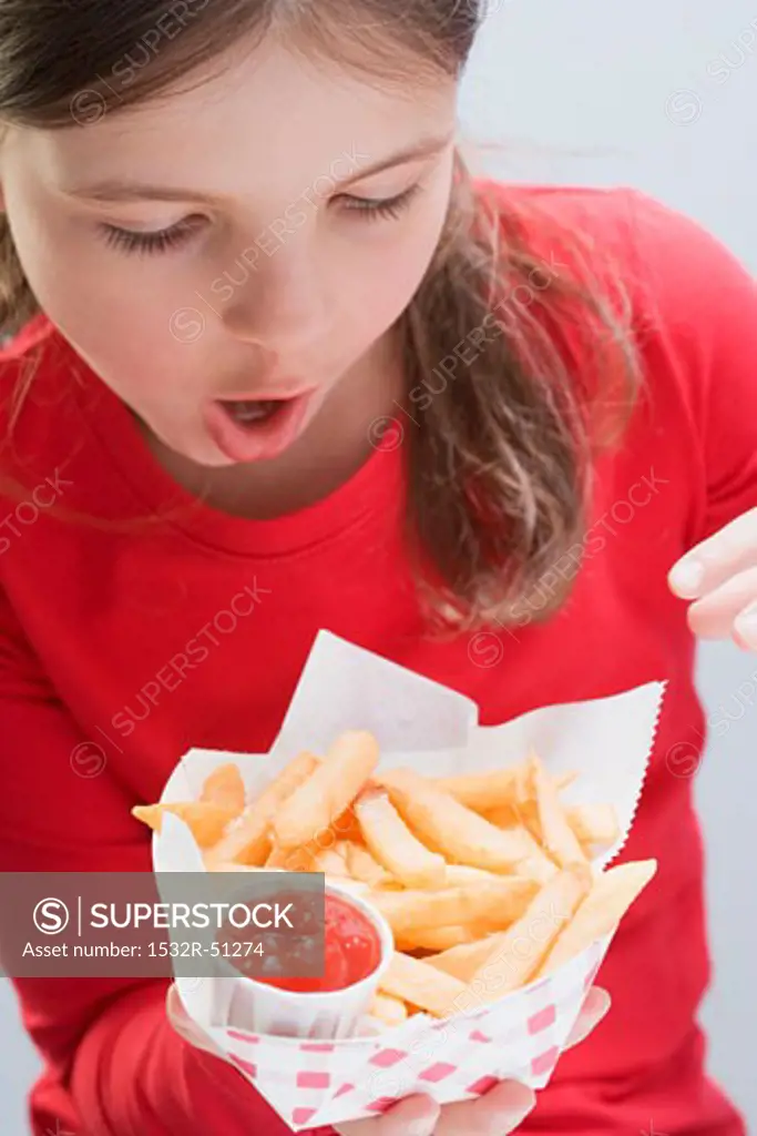 Girl holding chips with ketchup