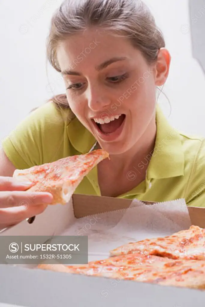 Young woman eating pizza