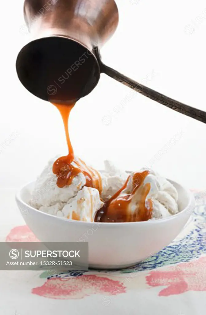 Pouring Caramel Sauce Over Bowl of Vanilla Ice Cream