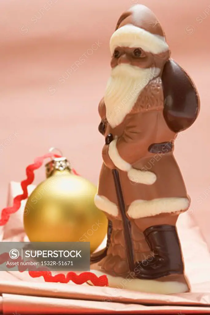 Chocolate Father Christmas beside Christmas bauble