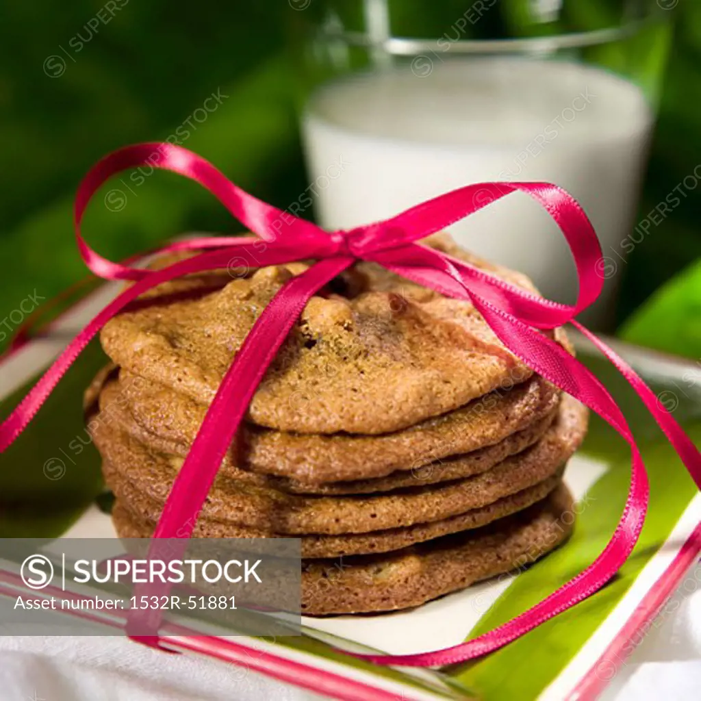 Stack of Cookies Tied with a Pink Ribbon; Glass of Milk