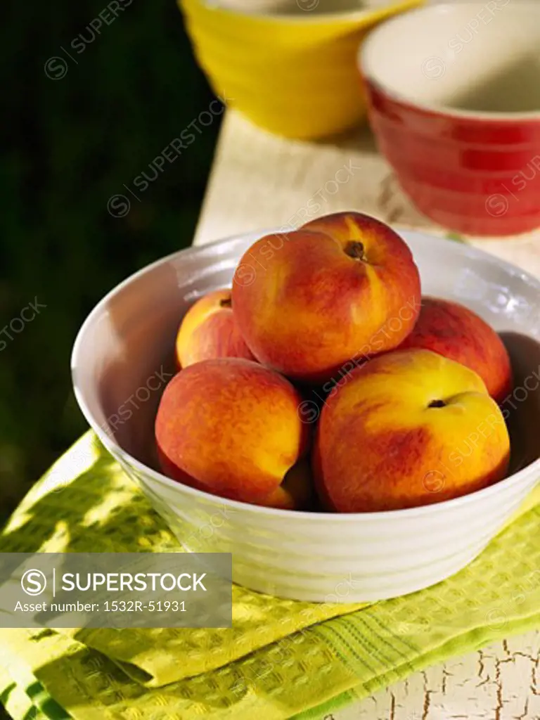 Bowl of Peaches on Folded Green Dish Towel