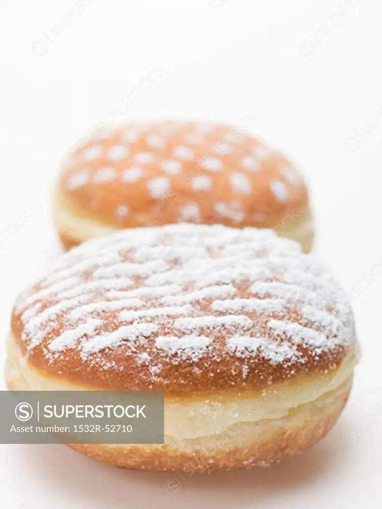 Two doughnuts dusted with icing sugar