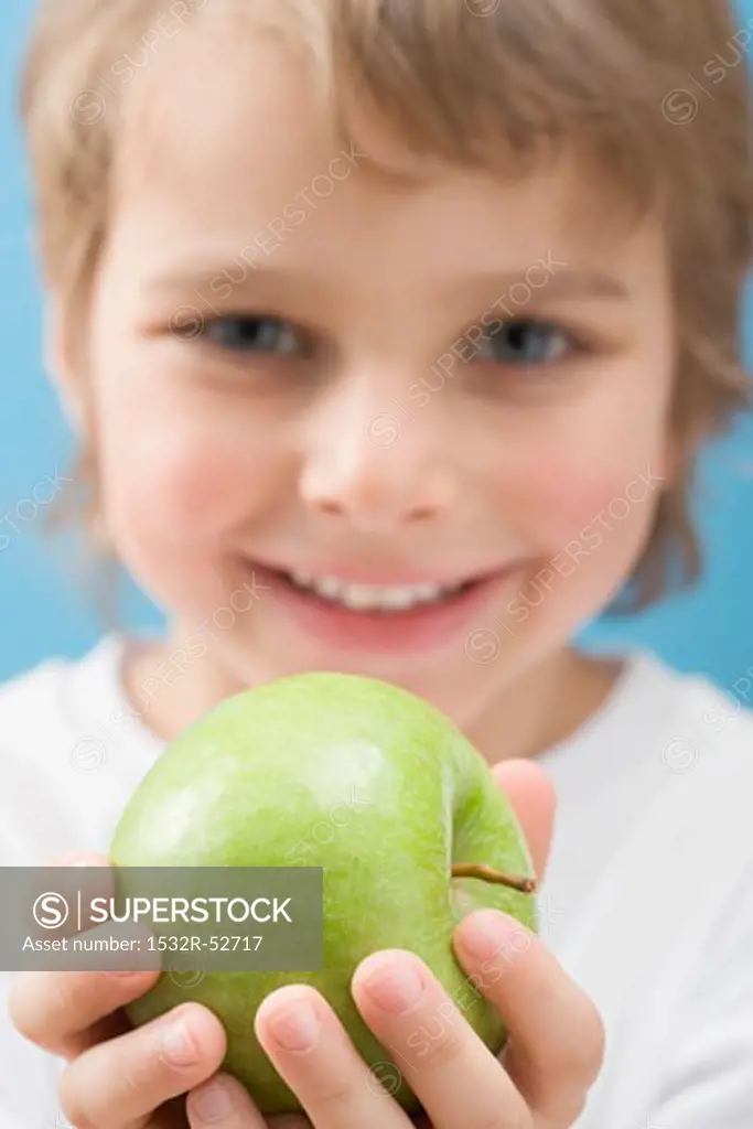 Little boy holding green apple